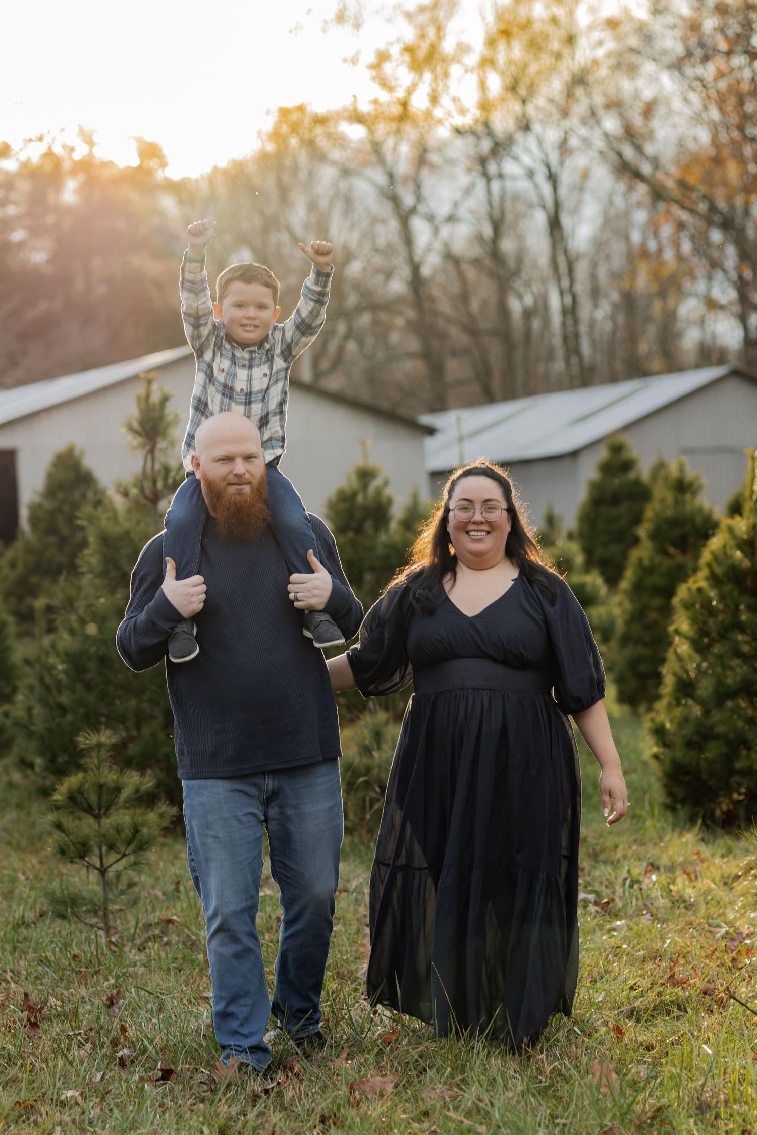 A family poses together outdoors at sunset among evergreen trees in their backyard. Richmond, VA Family photographer Affordable photographer