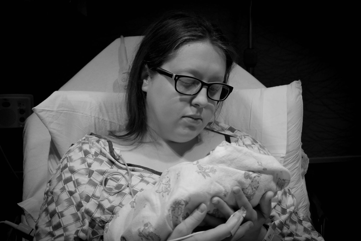 Black and white photos showing someone holding a baby in a hospital bed.