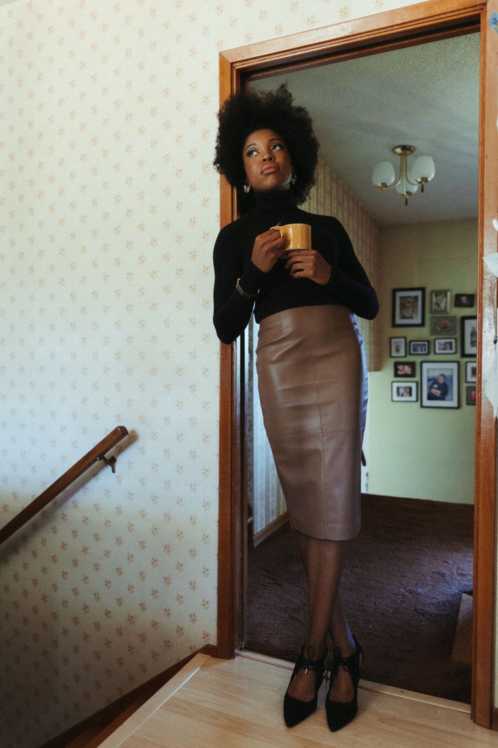 Series of mirror selfies showing a brown leather dress and black cardigan outfit in a hallway with floral wallpaper.