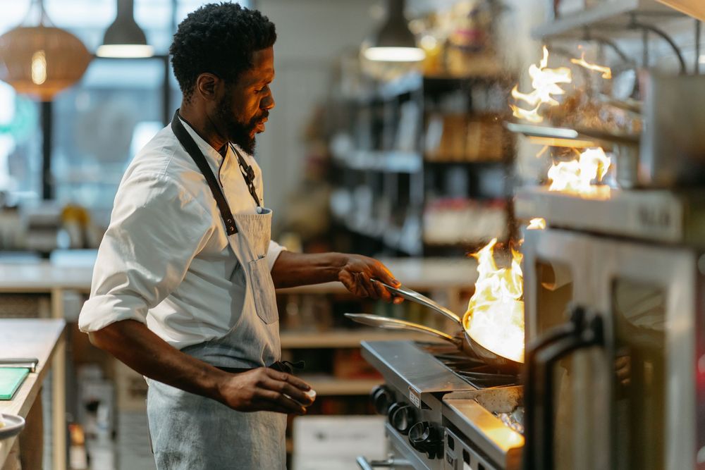 Chef working with digital tablet in professional restaurant kitchen.