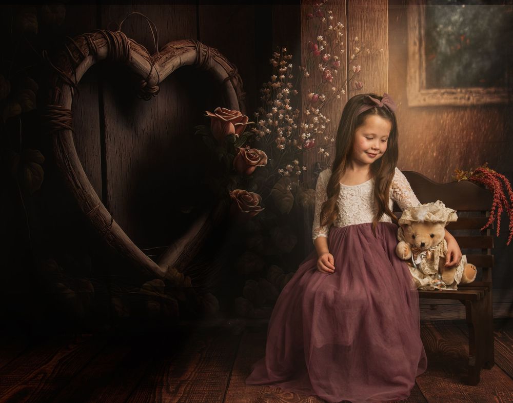 A woman in a burgundy dress sits in a rustic setting with vintage decor and warm lighting creating a cozy atmosphere.