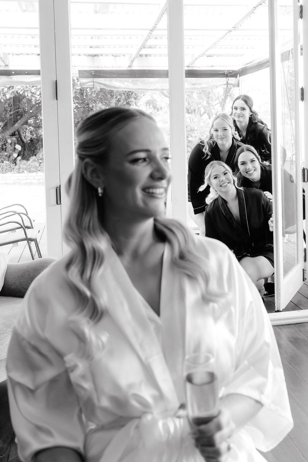 A series of candid black and white photos showing joyful moments during a wedding preparation.