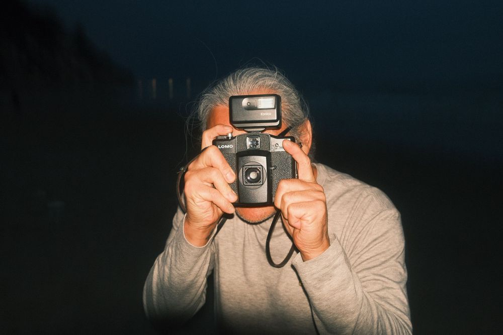 A sequence of photos showing someone taking a picture with a vintage camera in dim lighting conditions.