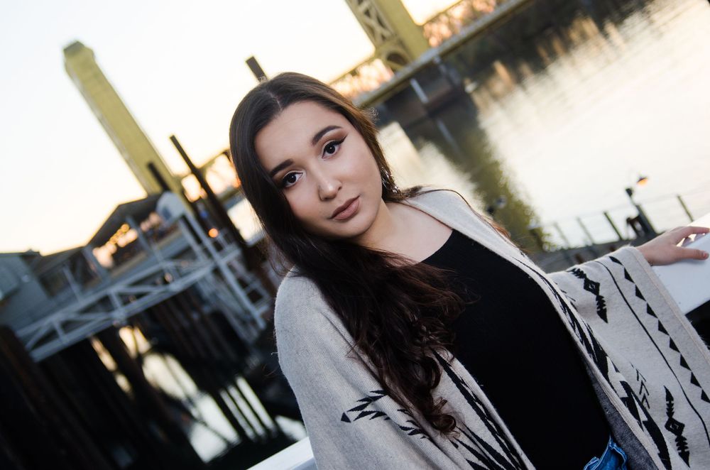 A series of five connected portrait photos showing someone in a black top against an urban background.