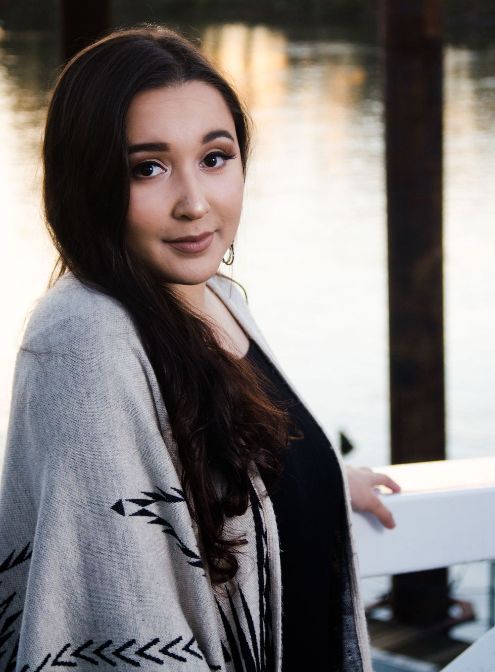 A person wearing a grey sweater poses against a dark background in a series of four connected photos.