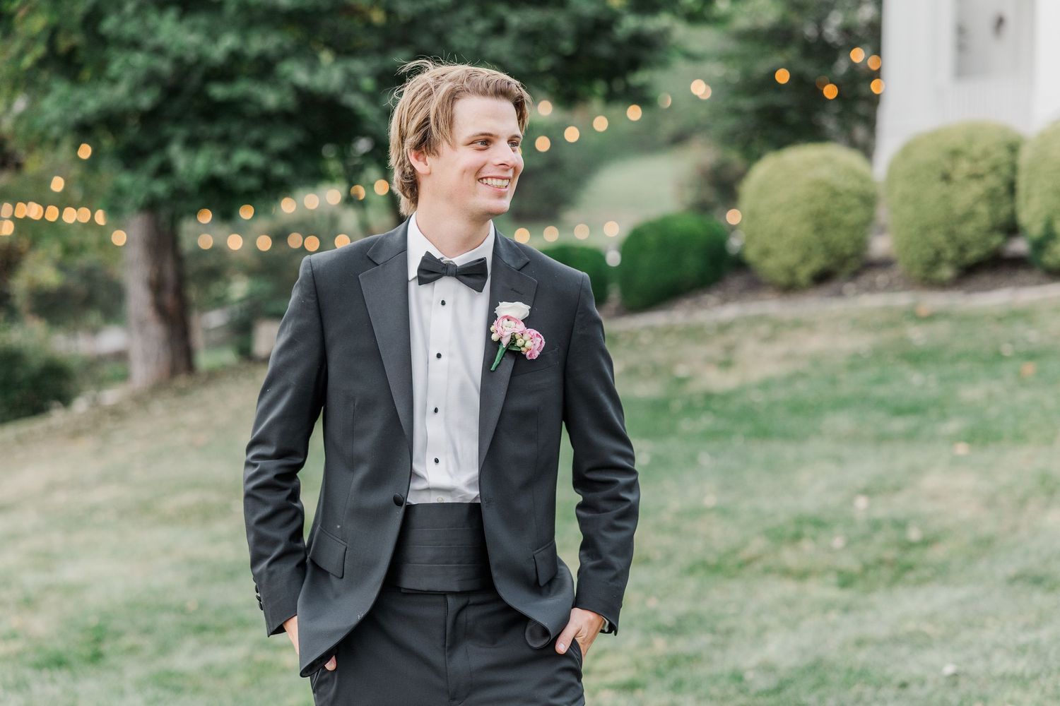 Elegant formal attire captured in a garden setting with string lights.