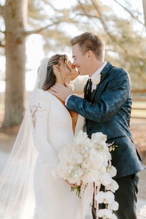 A romantic wedding sequence showing a couple sharing intimate kisses in a natural outdoor setting with white floral bouquet.