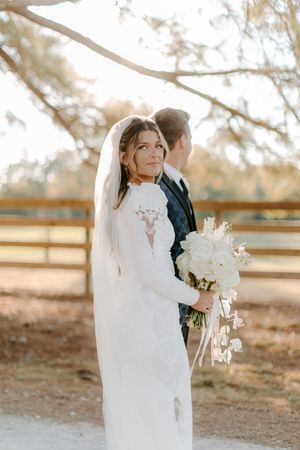A bride and groom share an intimate moment during their outdoor wedding photoshoot at sunset.