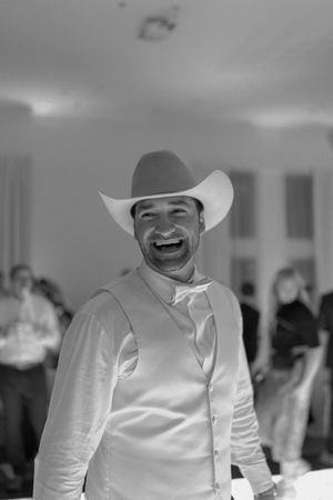 A person wearing a white cowboy hat and white shirt smiles warmly in a series of black and white photos.