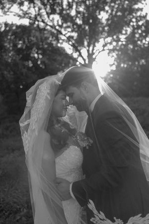Black and white romantic wedding photos show a couple sharing intimate moments in an outdoor garden setting.