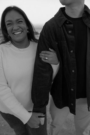 Black and white image showing people wearing white tops and black jackets posing together in a casual style.