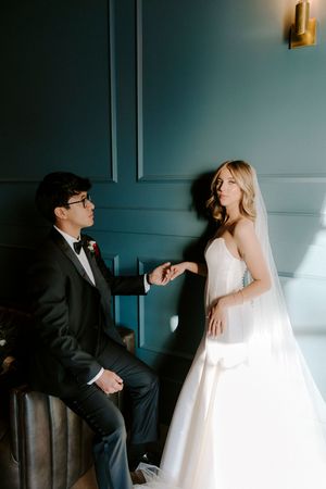 A series of artistic wedding photos showing a couple in formal attire against a dark teal wall with dramatic lighting.