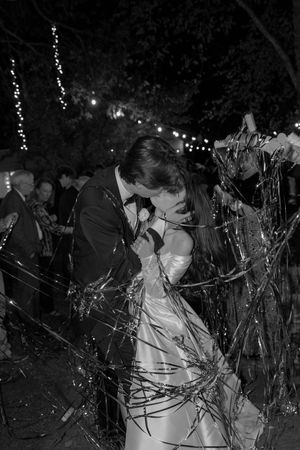 People celebrate at a nighttime party with streamers and confetti flying through the dark atmosphere.