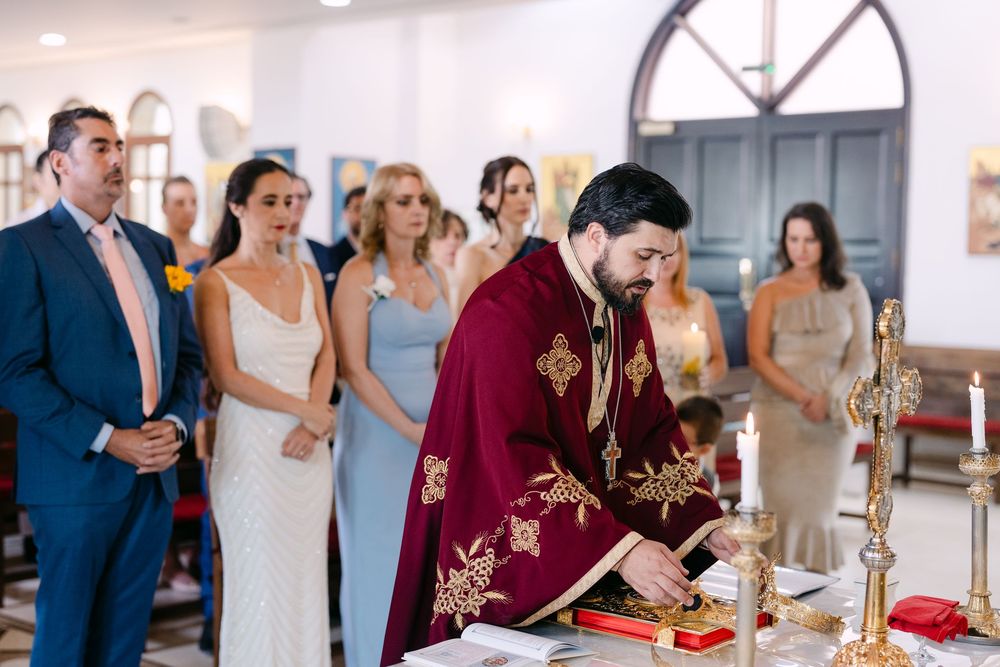 Wedding guests gather around an elegant buffet table to serve themselves during an indoor reception celebration.