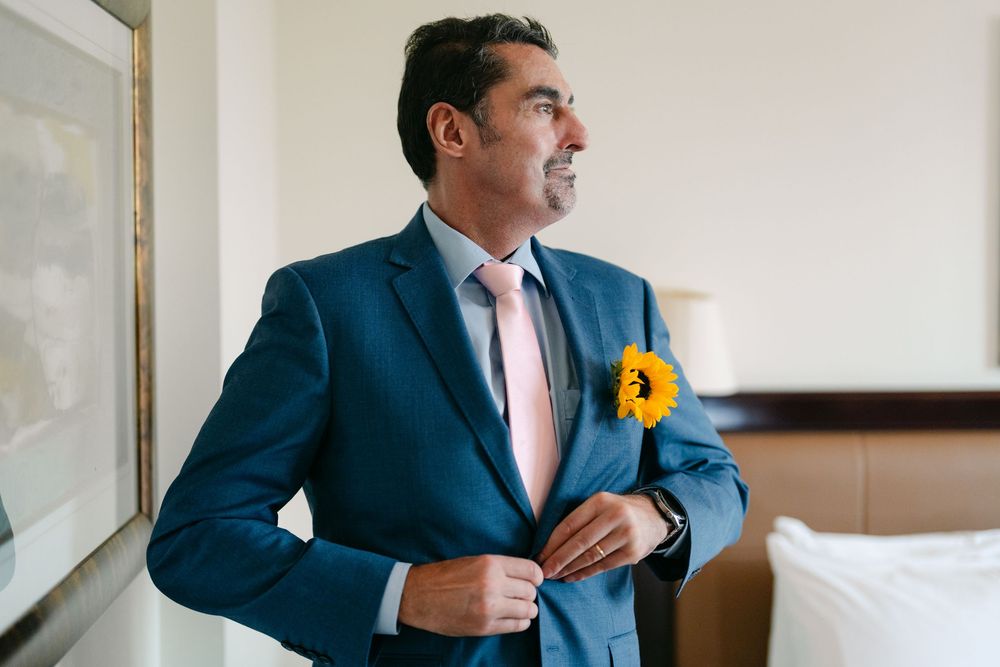 Person in a blue suit jacket standing near a window in an office setting.