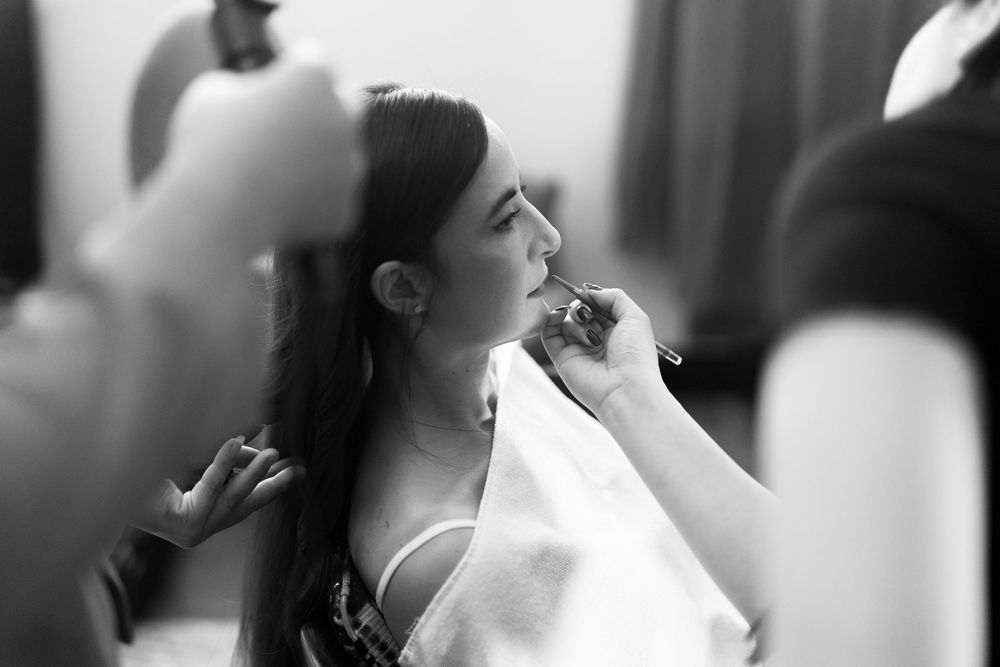 Black and white photo series showing someone having makeup applied in a getting ready sequence.
