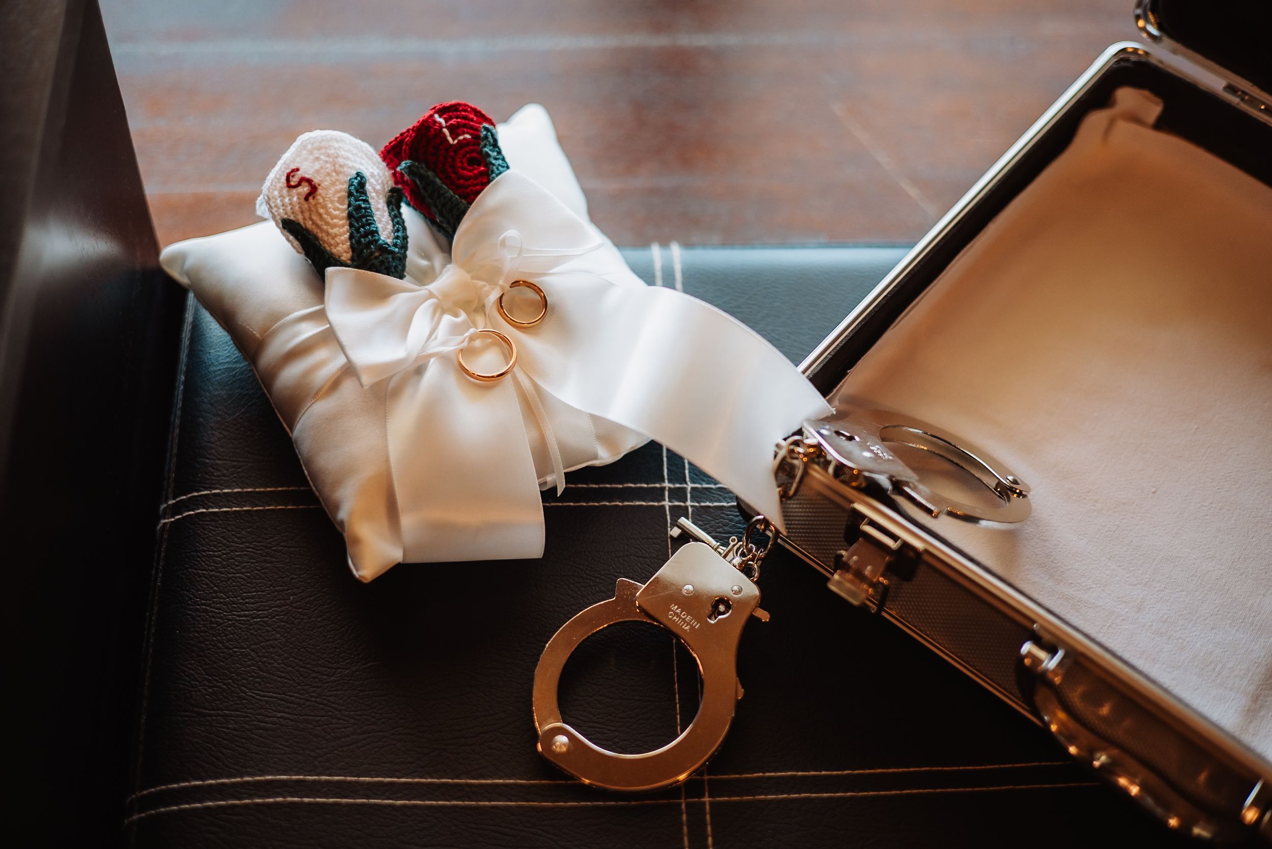 Wedding rings displayed on a white satin ribbon with elegant lighting and soft focus.