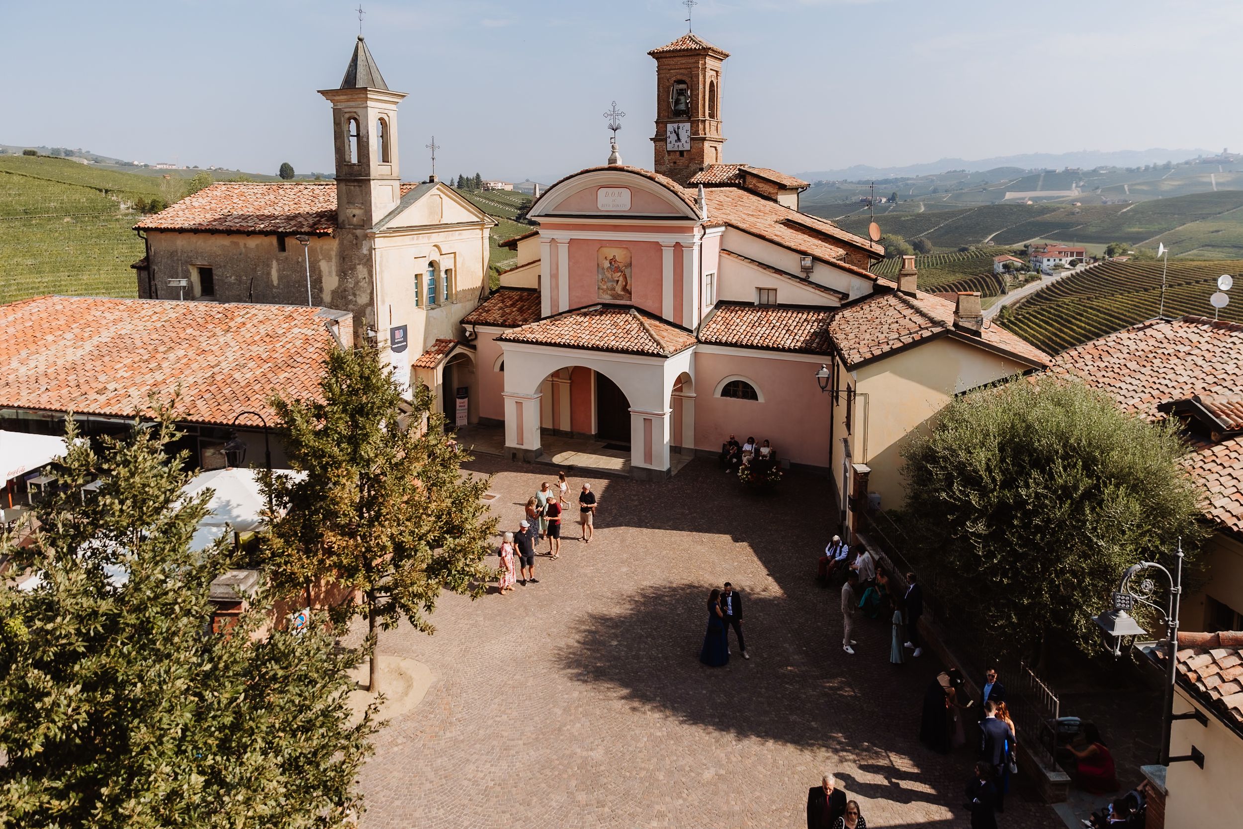 Scenic panoramic view of Italian countryside with traditional stone buildings and rolling hills in the distance.