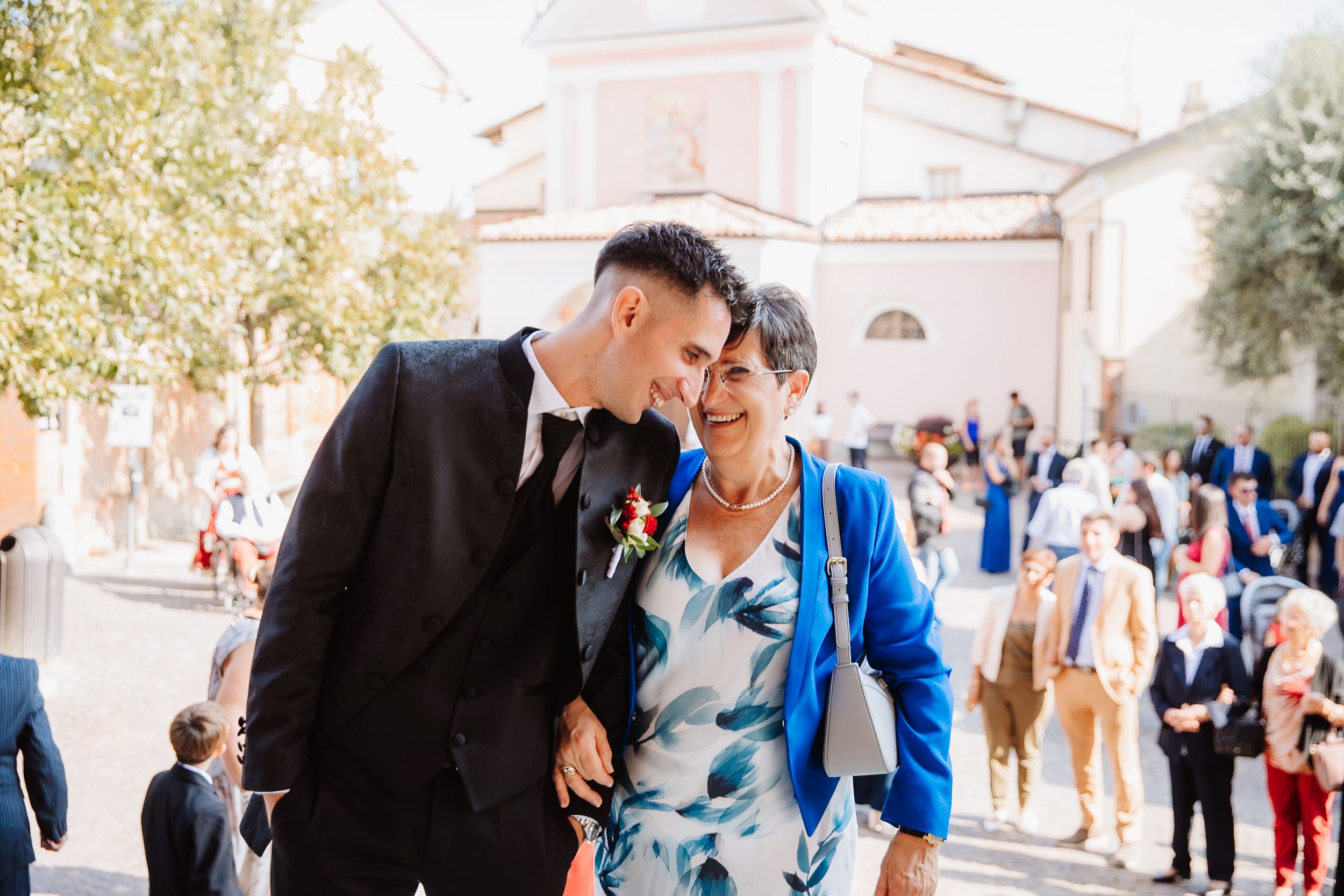 A joyful moment shared between people at an outdoor event with brick buildings in the background.