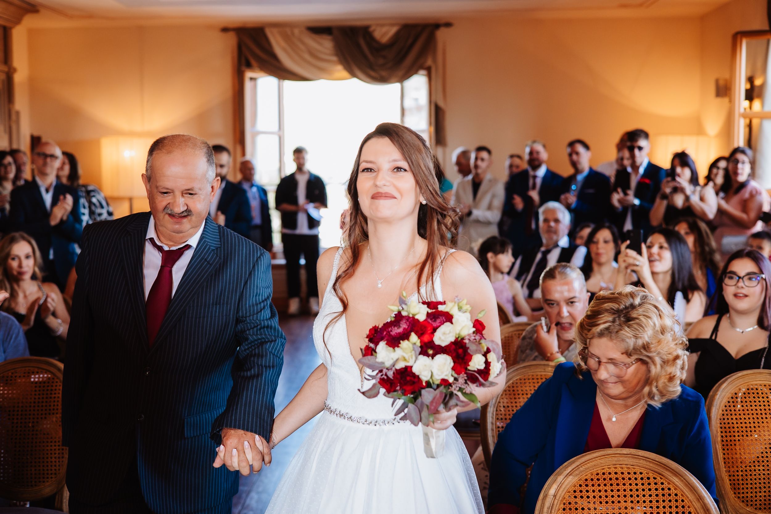 Wedding ceremony guests watch emotional first dance of newlyweds in elegant ballroom setting.