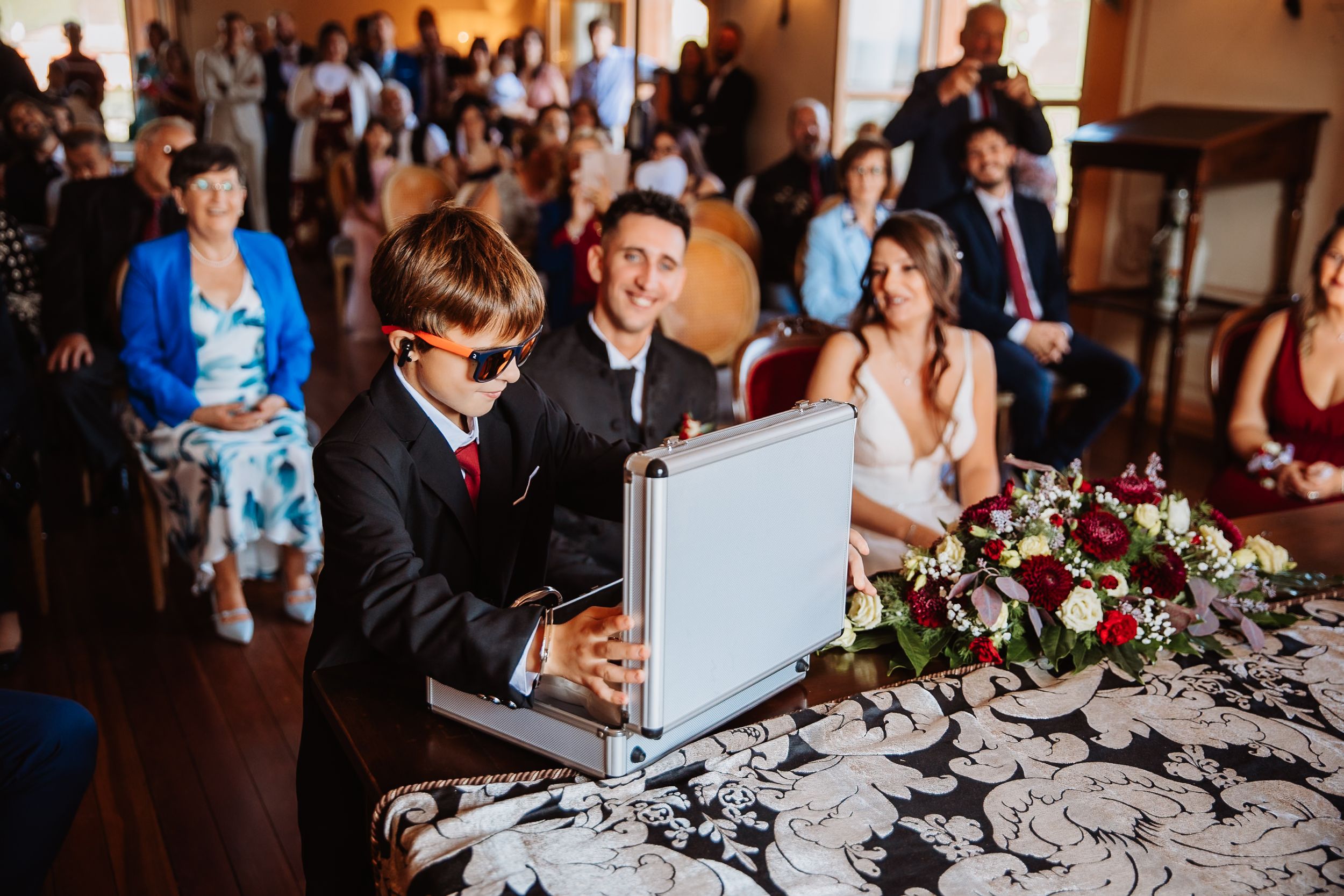 Wedding reception venue decorated with elegant gray linens and floral centerpieces on dining tables.