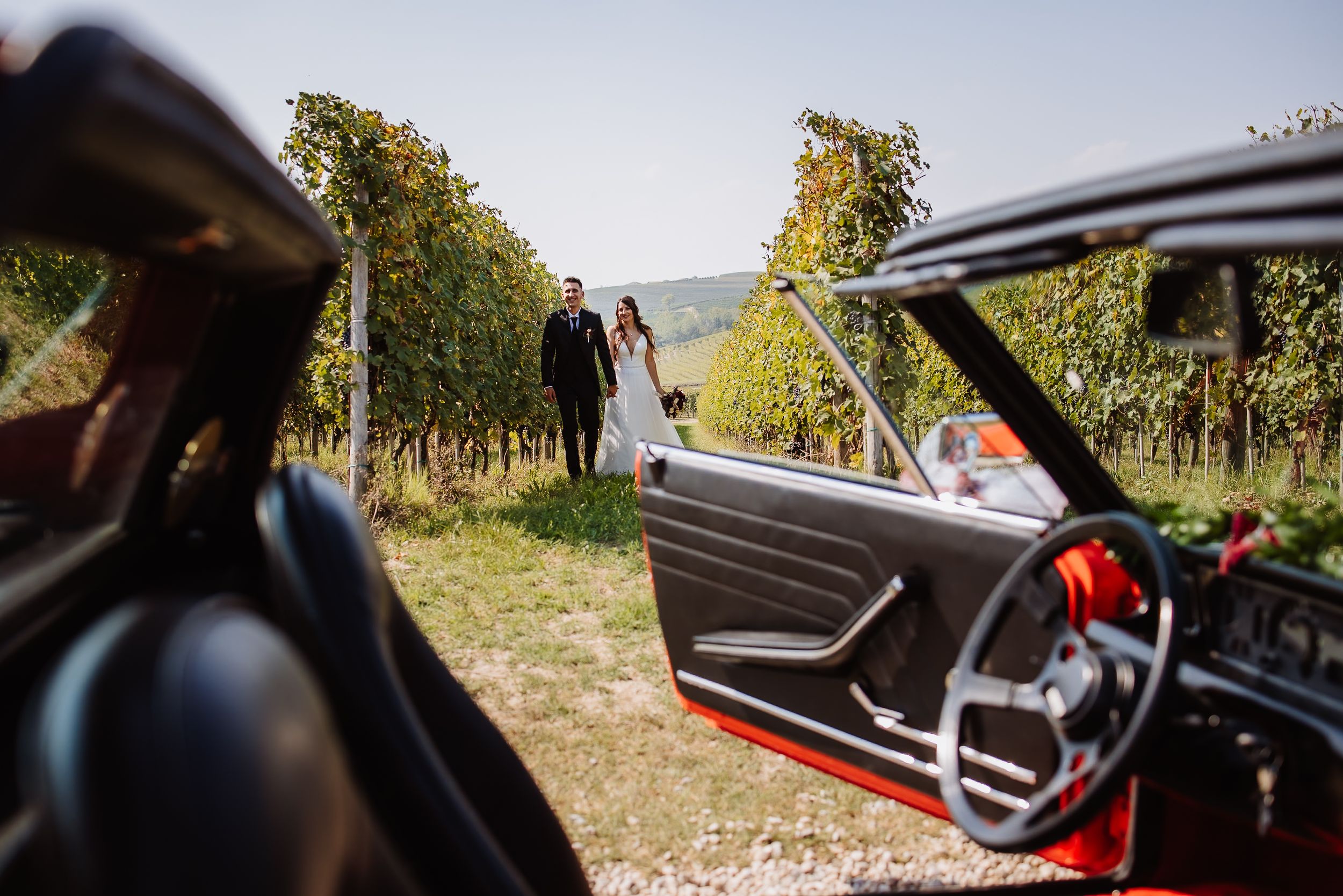 A collection of interior and exterior shots of a luxury car driving through scenic vineyard roads on a sunny day.