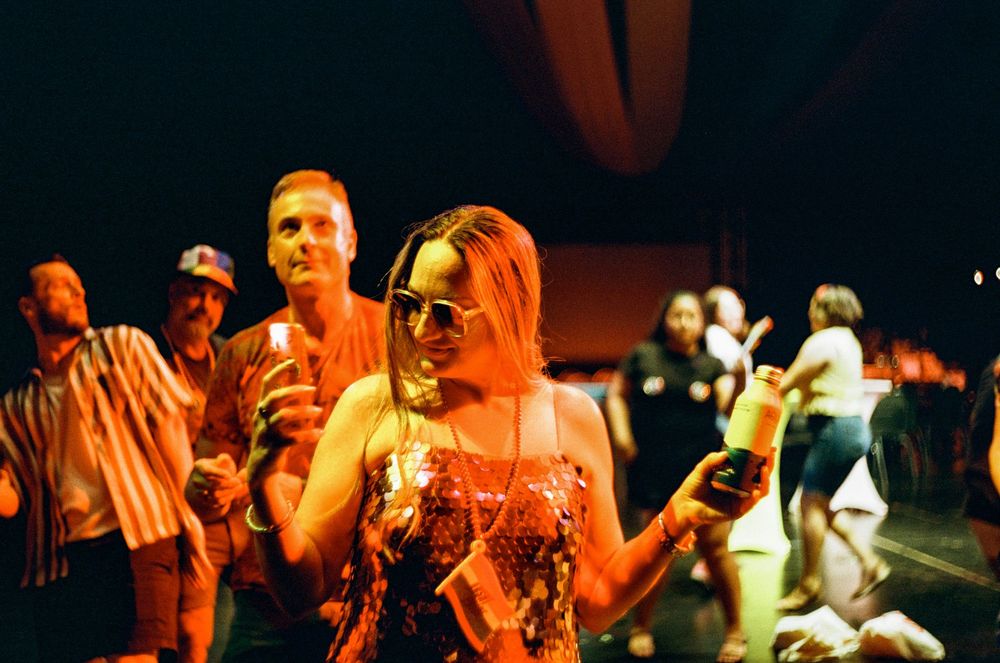 Party-goers enjoying themselves on a vibrant dance floor with sunglasses and festive atmosphere.
