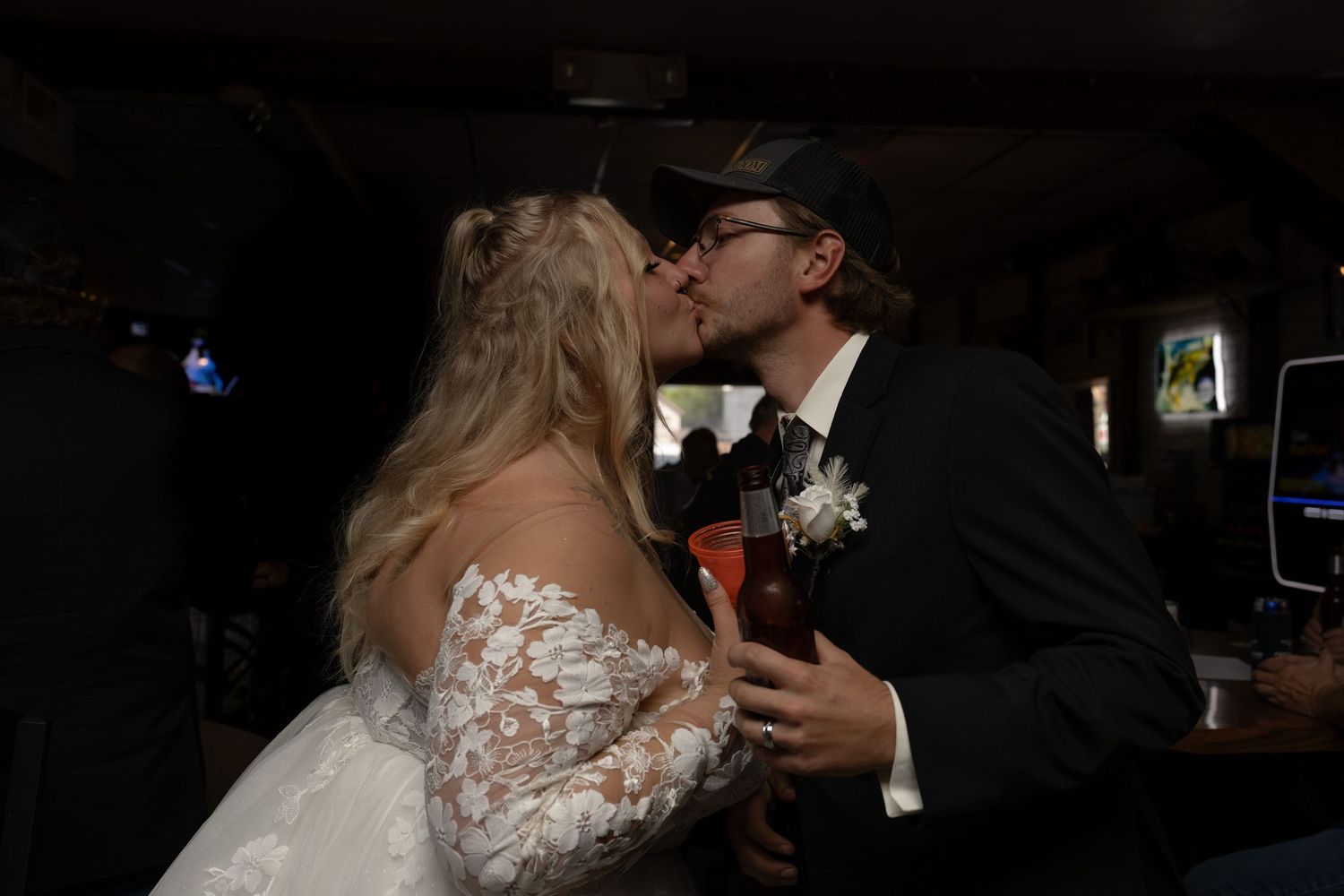 Bride and groom kissing at a bar in Garrison North Dakota before their wedding reception photography session