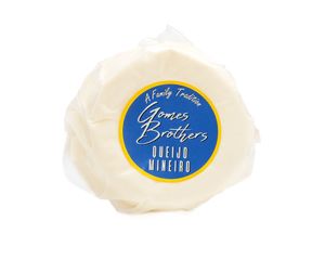 A round wheel of white cheese with a blue and gold Amish Brothers English Farmstead label on top.