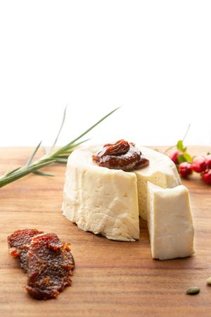 Fresh goat cheese and fig chutney appetizers arranged on a wooden cutting board display a rustic presentation.
