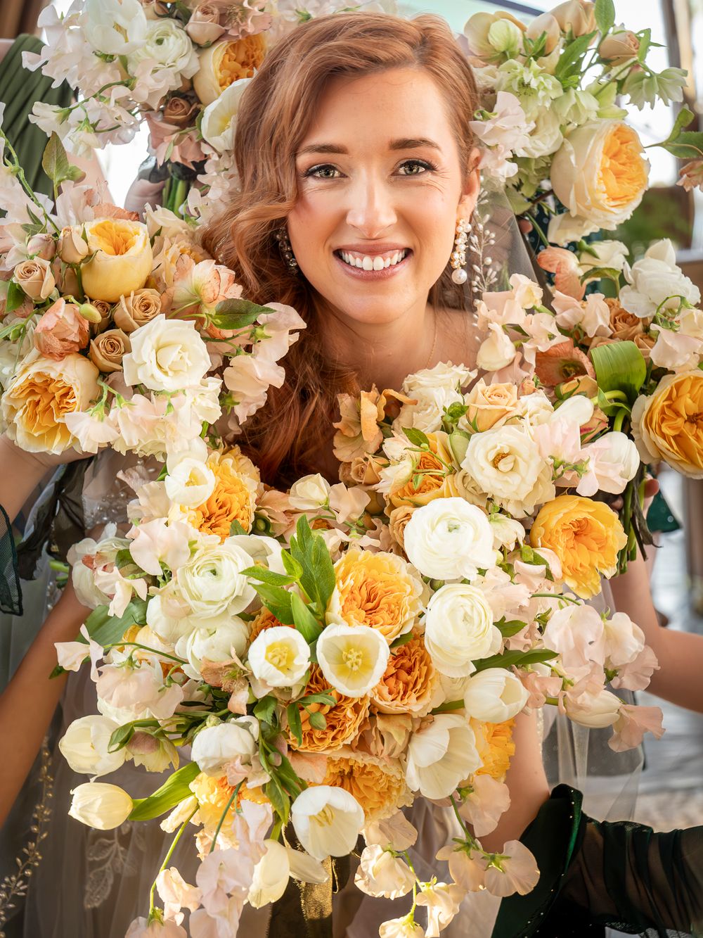 A stunning bridal bouquet features peach garden roses, white orchids and cream flowers in a lush cascading arrangement.