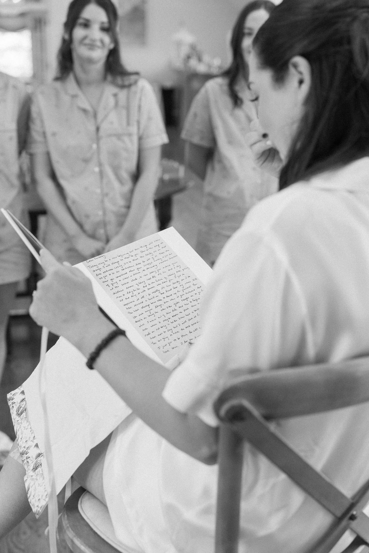 A moment captured during wedding preparations as someone reads from a handwritten note.