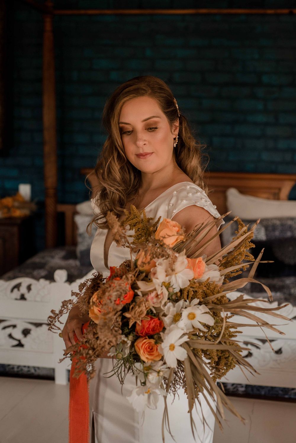 The bride holding her bohemian inspired bouquet in fall colours.