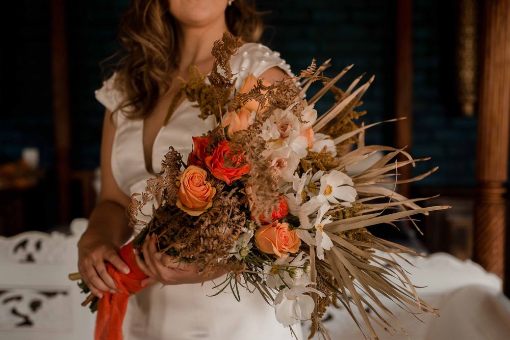 The bride holding her bohemian inspired bouquet in fall colours.