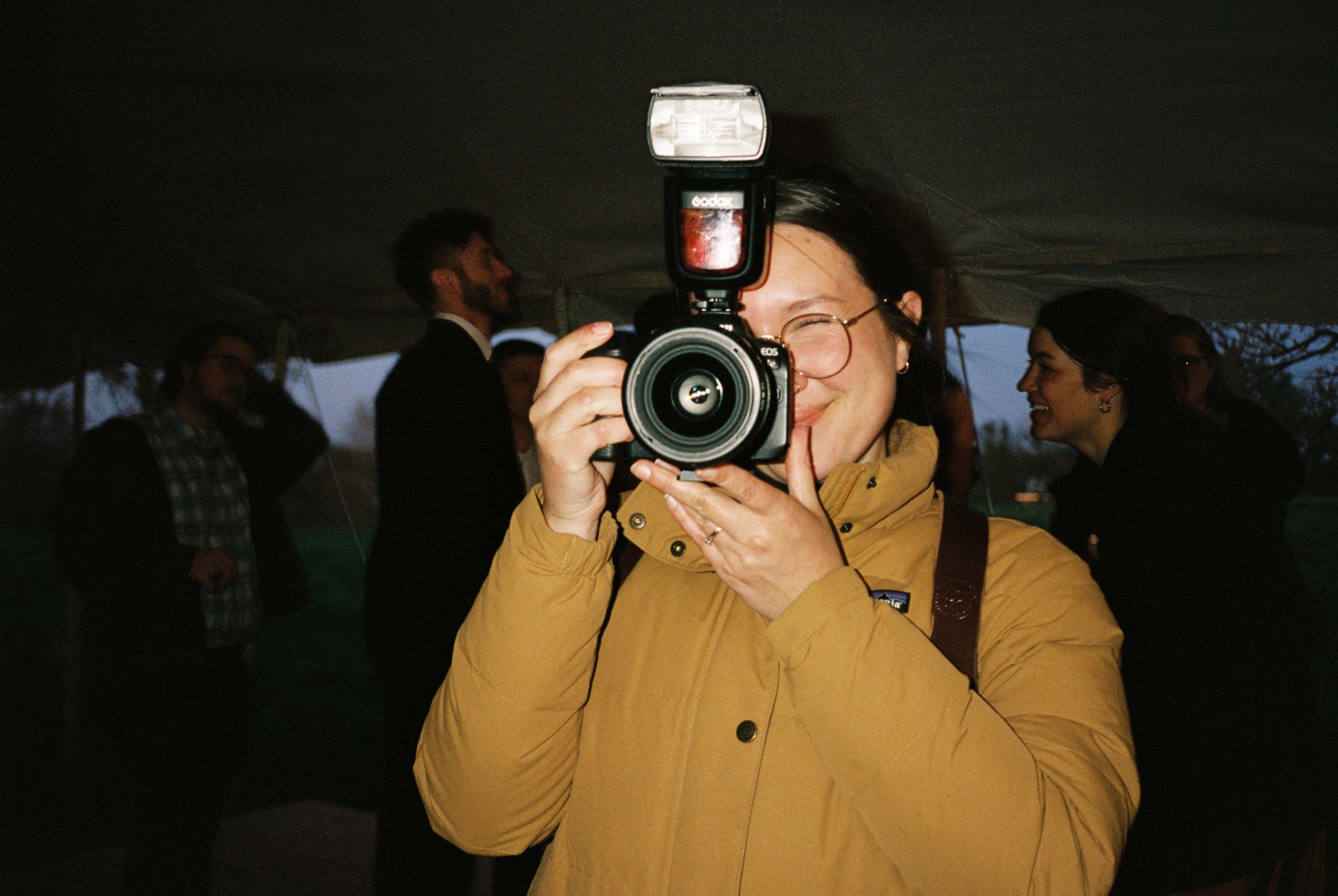 A sequence of six photos showing someone in a yellow coat taking pictures with a professional camera.