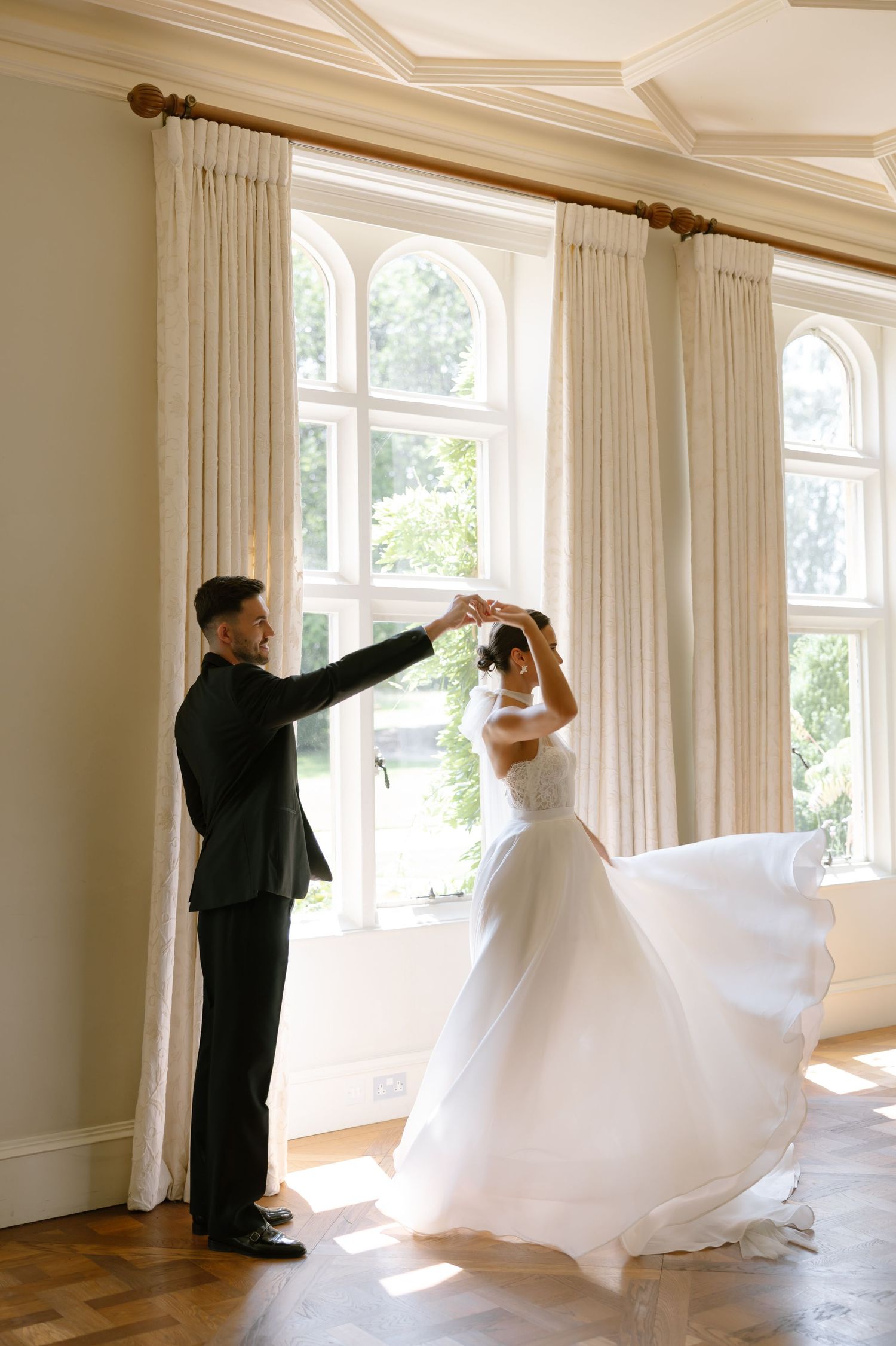 Series showing the dramatic movement of a white ballgown wedding dress in a sunlit room.