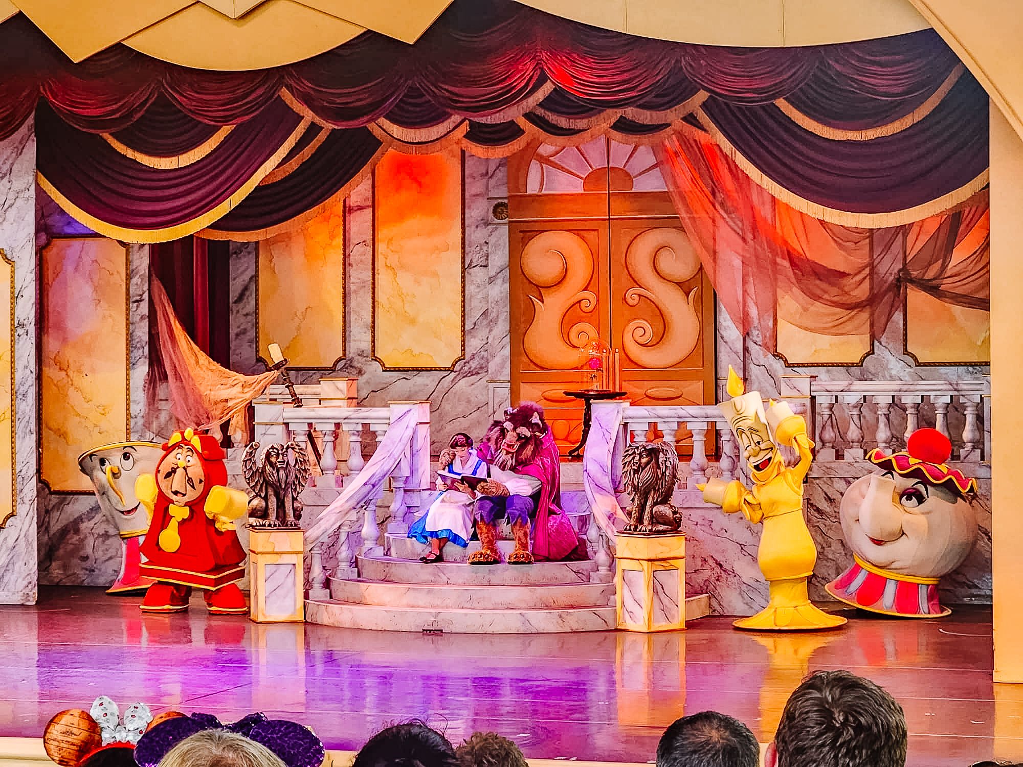 Stage performance of Beauty and the Beast with elaborate set design and character costumes.