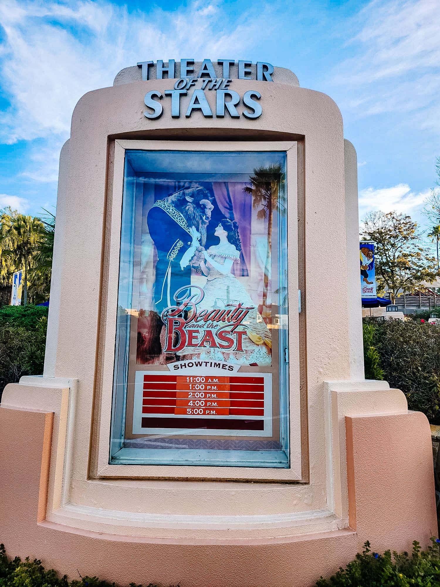 Digital display signs at Theater of the Stars showing various Disney show titles against pink architectural elements.