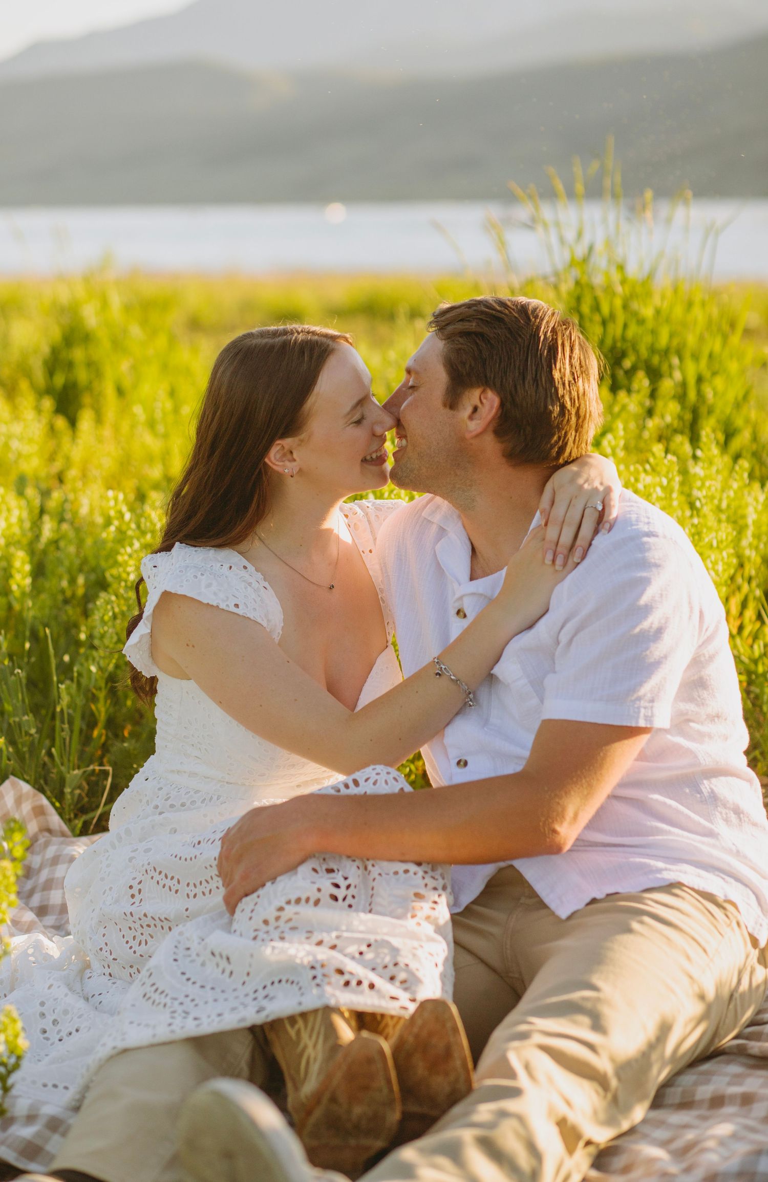 A couple shares an intimate moment along a forest path lined with evergreen trees and birch during a wedding photo session.