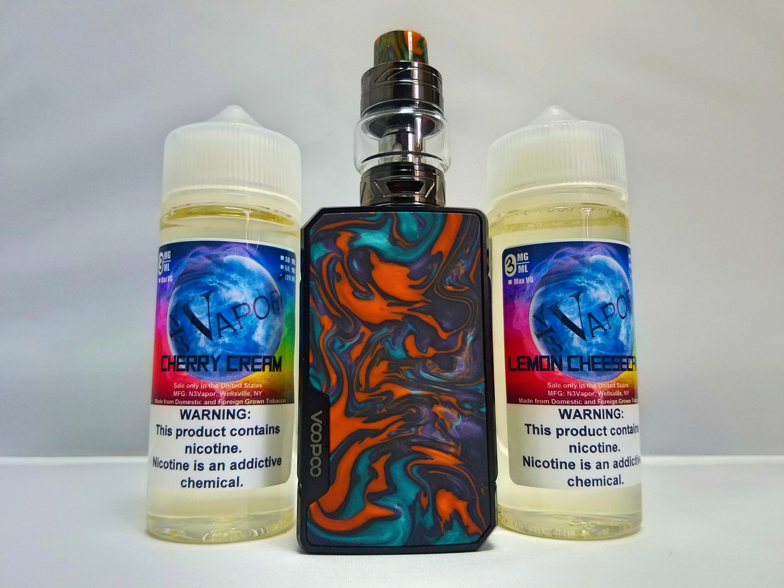 Colorful vape mod displayed with two e-liquid bottles featuring blue label designs.