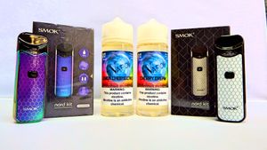 Display of vaping devices and e-liquid bottles arranged with retail packaging.
