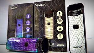 Multiple SMOK brand vaping products arranged in a horizontal display showing packaging and devices.