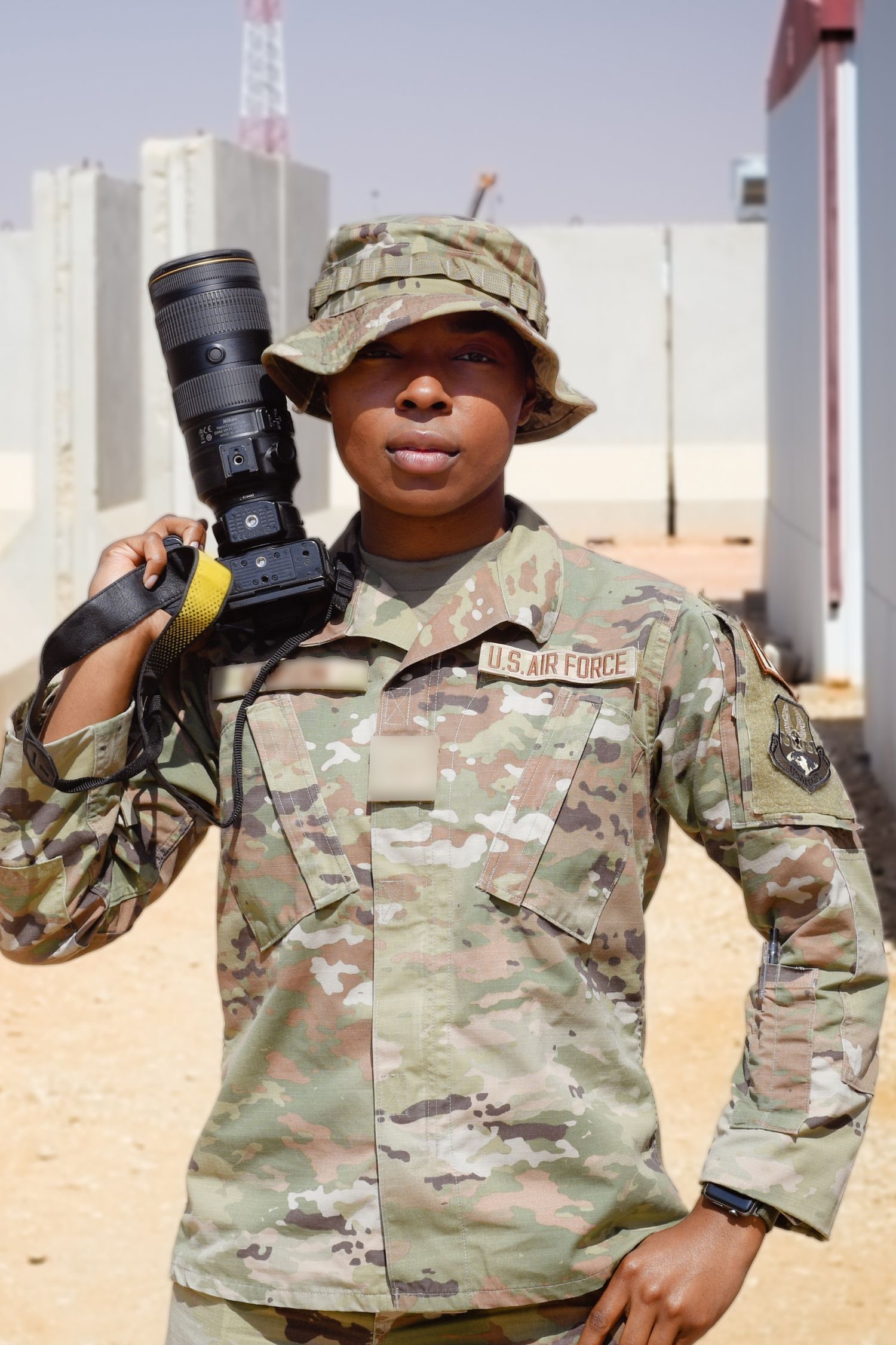 Four similar photos of a soldier in camouflage uniform holding up camera equipment against a sandy background.
