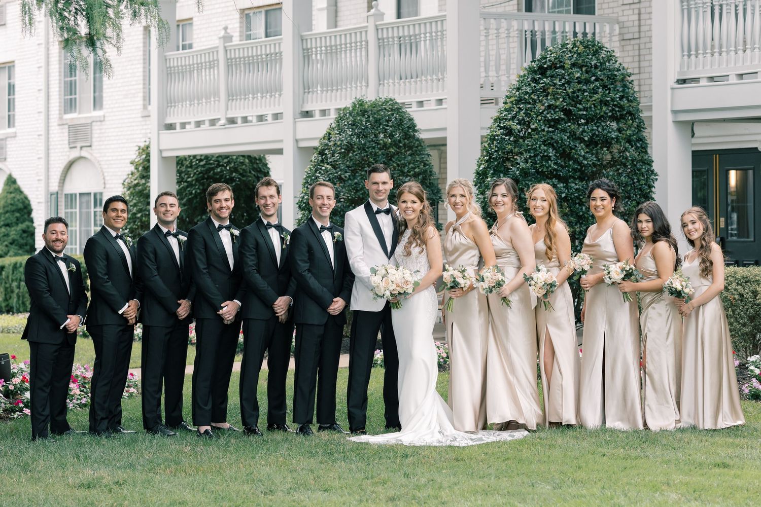A wedding ceremony takes place under a historic brick archway as guests look on from both sides of the aisle.