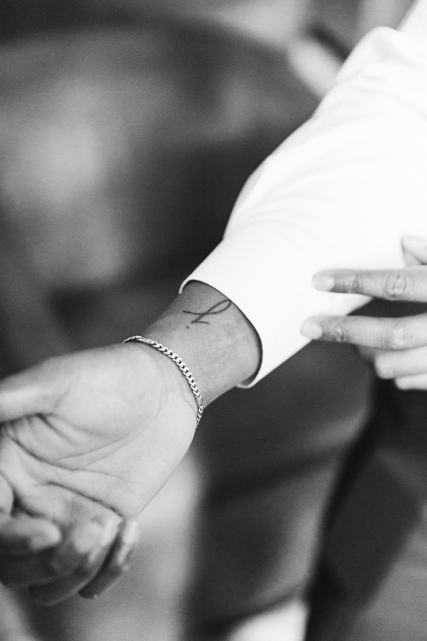 Black and white image of hands adjusting formal wear accessories.