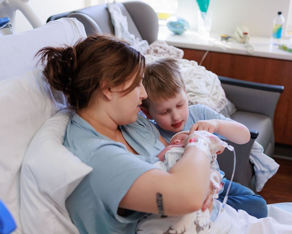 A tender moment in a hospital room as a family bonds with their newborn baby.