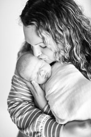 Series of intimate black and white photos showing tender moments with a sleeping newborn.