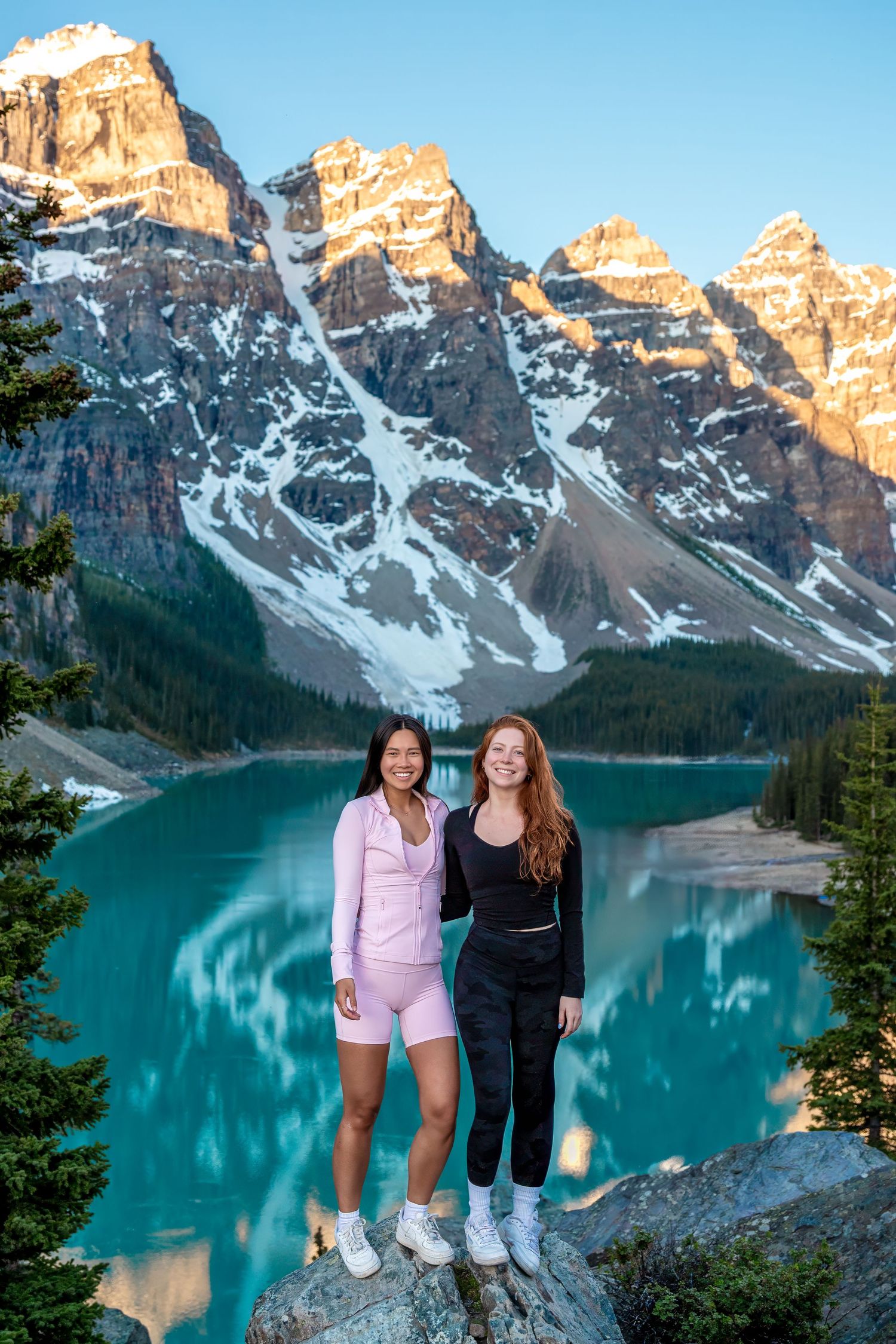 A winter scene with a family enjoying ski activities outside a snow-covered log cabin.