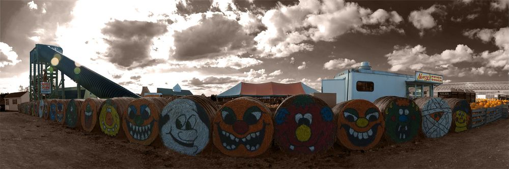 A panoramic view of colorful street art murals and smiling graffiti characters made of hay. (Henrietta NY)