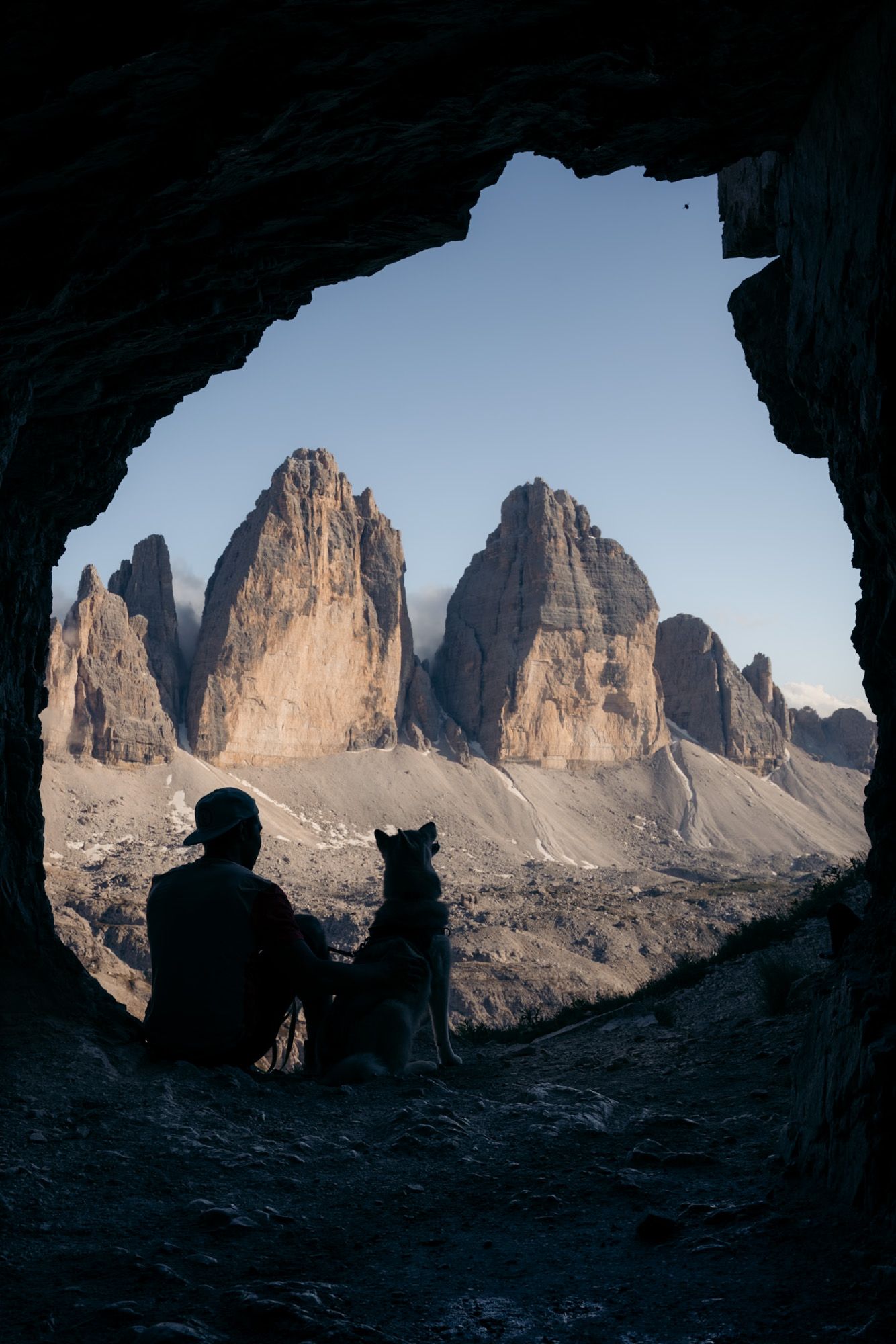 un homme et son chien dans la grotte devant les tre cime di lavaredo dans les dolomites